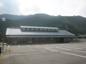 平たい建物とその手前にある車複数台分のスペースを持つ駐車場の写真
