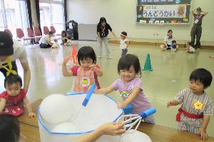 エプロンをつけて大きなボウルをかき混ぜている様子