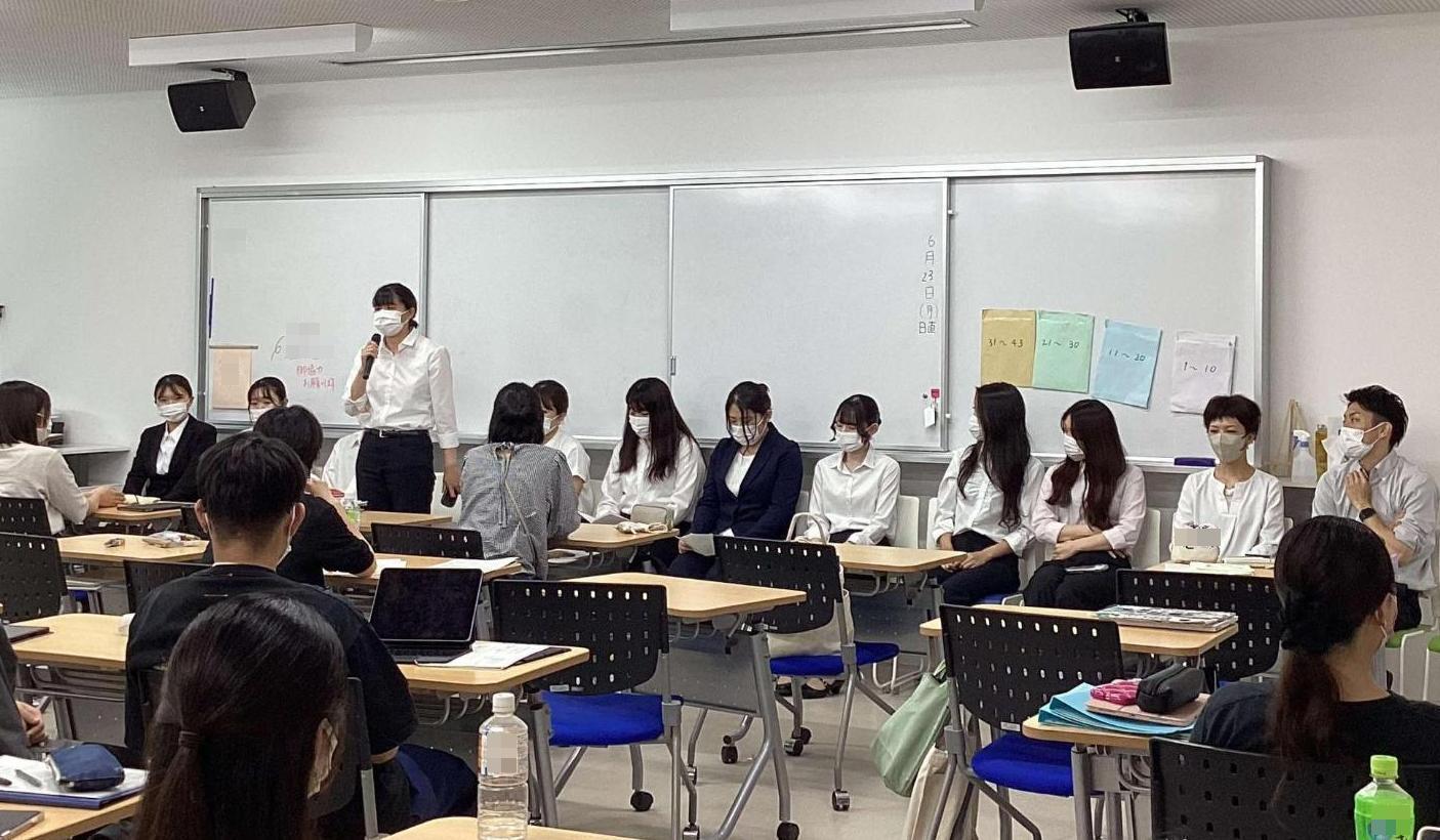 卒業生12人の中の1人が立って、3年生へ看護師の仕事の様子などを話している写真