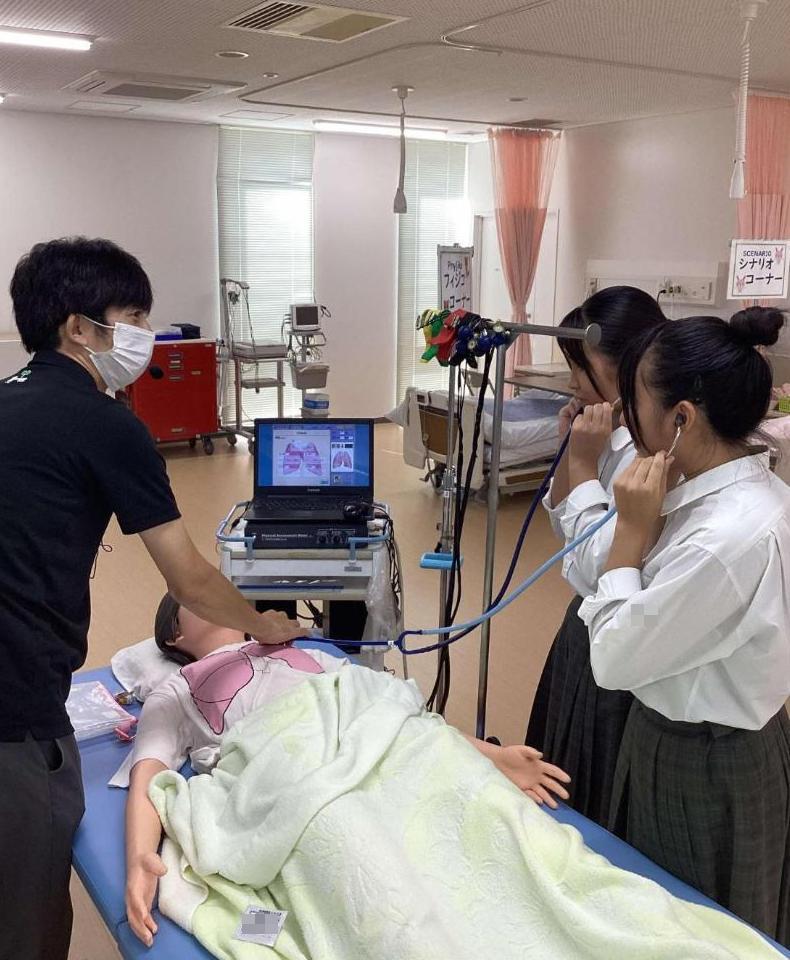 シミュレーター人形の呼吸音を聞いている参加者の写真