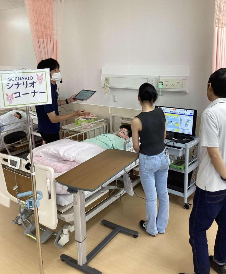 シミュレーター人形について教員から説明を聞いている参加者の写真