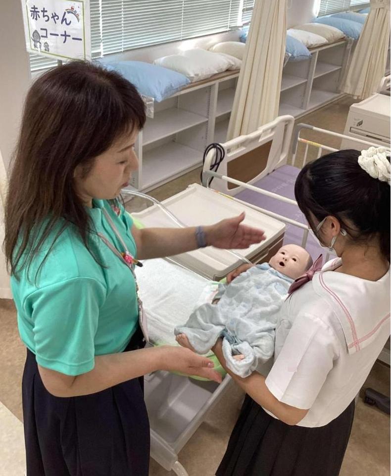 参加者が赤ちゃん人形を抱っこしている写真