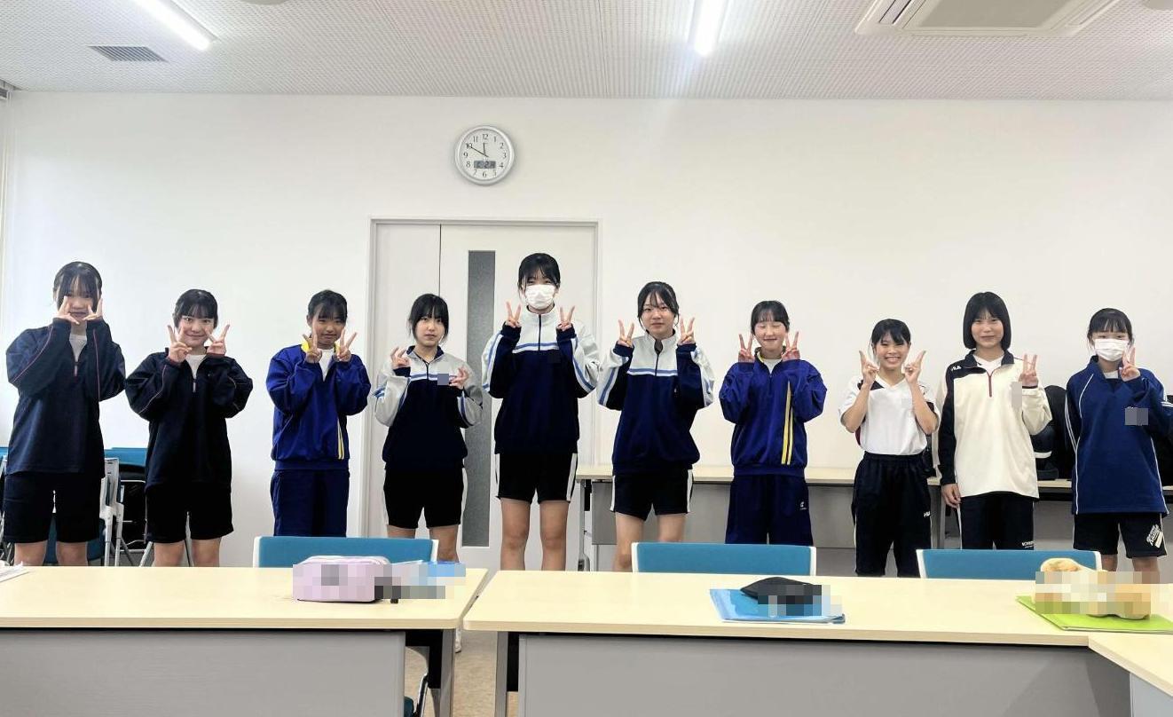 室内でピースサインをしている中学生10人の写真