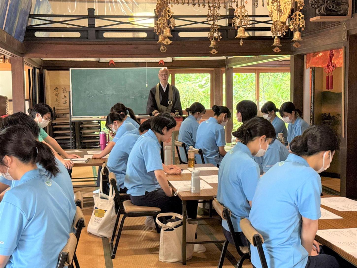 寺院で故人をしのぶ家族の心理的変化やグリーフケアの実際を教わっている学生達の写真