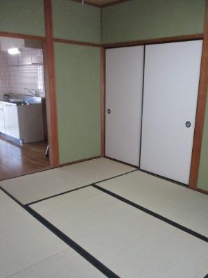右側に白い襖があり、奥の部屋がキッチンスペースになっている和室の写真