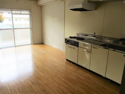 白を基調としたキッチンスペースのあるフローリングの部屋
