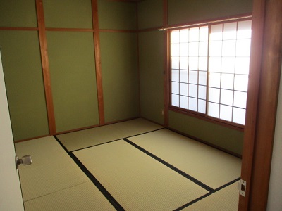 出入り口から撮影した、2階にある右側に窓のある緑色の壁の和室の写真