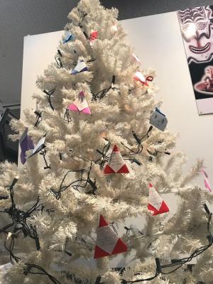 白いクリスマスツリーに折り紙でできたサンタクロースやイルミネーションが飾られている写真