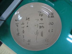 俳句が書きつけられた丸い皿の写真