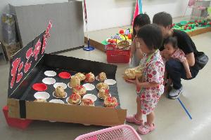 たこ焼きボールを投げて、上手くカップの中に入るか挑戦している様子
