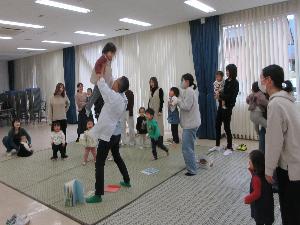 講師にこどもがだっこされそれを見守るお母さん達の様子