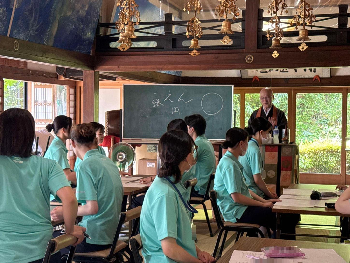 寺院で故人をしのぶ家族の心理的変化やグリーフケアの実際を教わっている学生達の写真