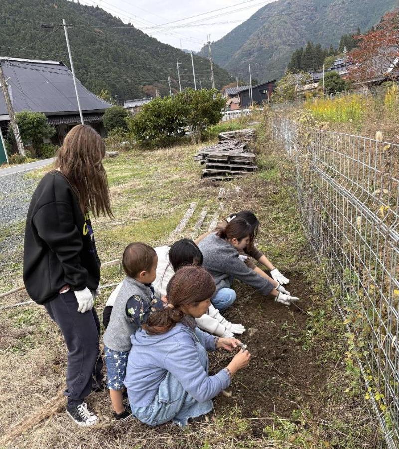 地域の方とチューリップの球根を植えている学生たちの写真
