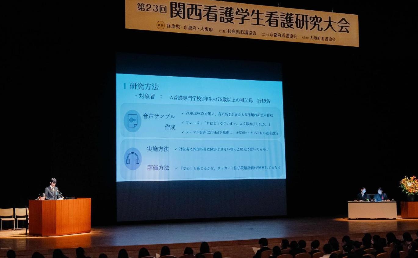 スクリーンに発表内容が写し出され、発表をしている学生の写真