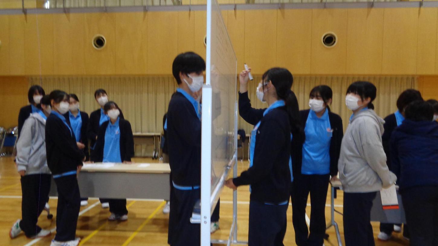 記トリアージの優先順位を考えた後、ホワイトボードに書き出している学生2人と、それを見ている学生たちの写真