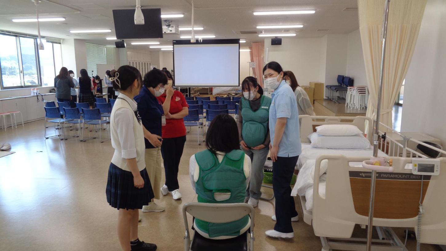 実習室で妊婦体験スーツを着た参加者たちの写真
