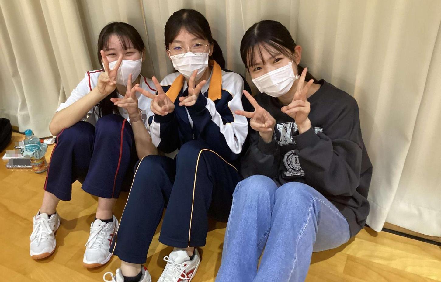 ドッチビーの試合後に3人でピースサインしている学生たちの写真