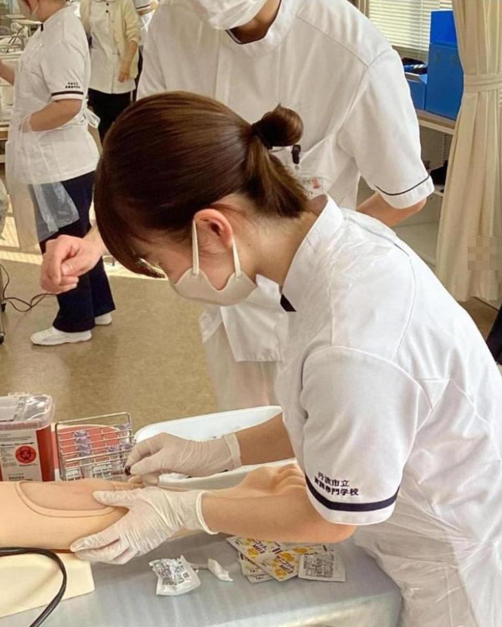 注射器を刺して採血している学生の写真