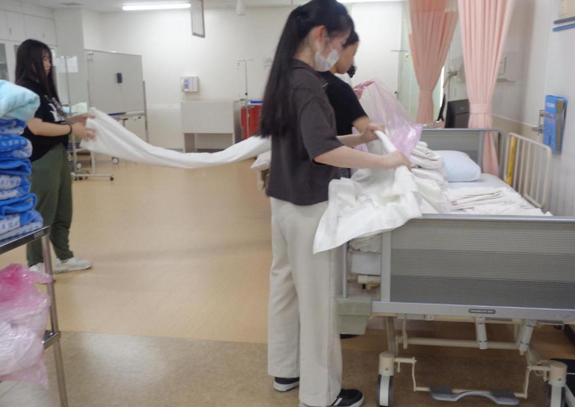 実習室のシーツを洗濯するための準備をしている学生たちの写真