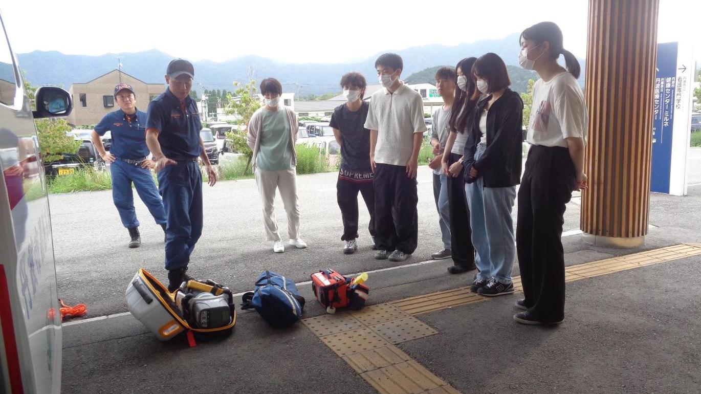 救急車両に積載している機材の説明を受けている学生たちの写真