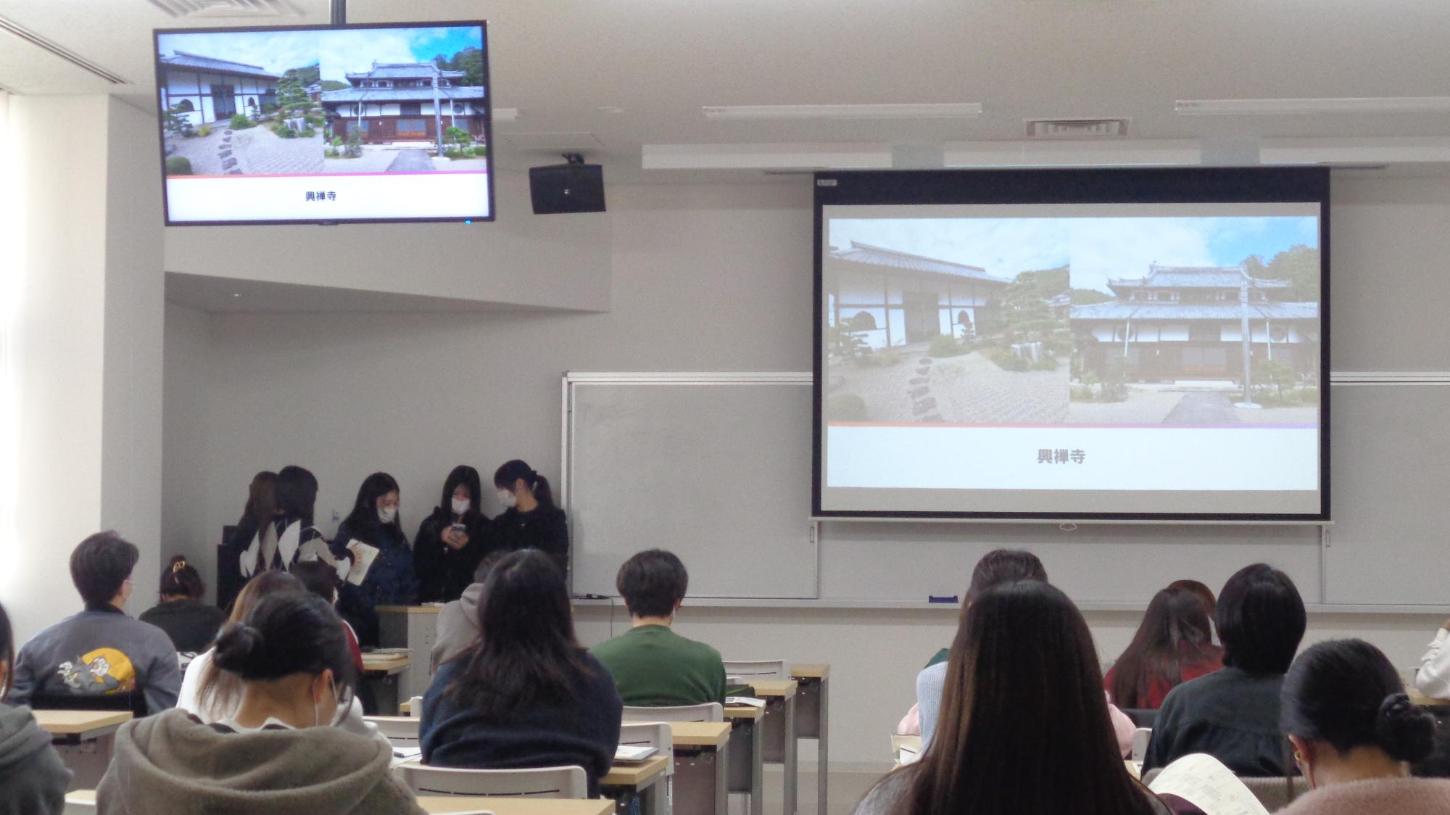 スクリーンに興禅寺の写真があり、学生がそれを見ている写真