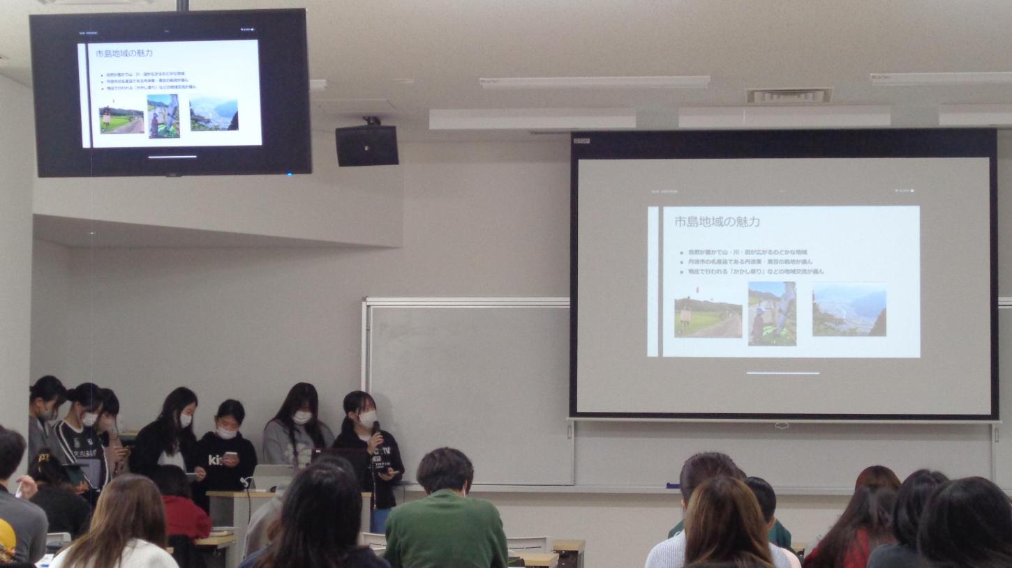 スクリーンとディスプレイに映された「市島町の魅力」について、数人が発表を行っている写真