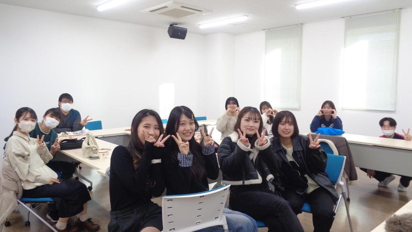 卒業生たちが笑顔でピースサインをしている写真