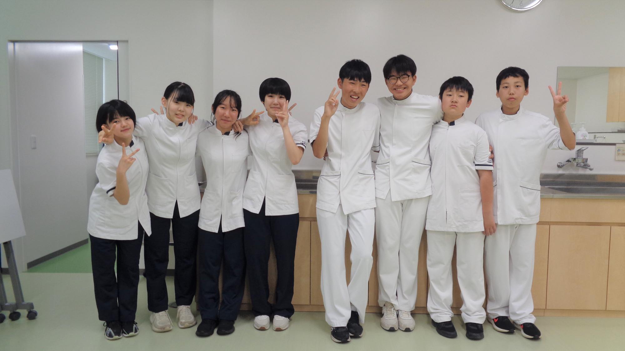 室内でピースサインをしている中学生達の写真