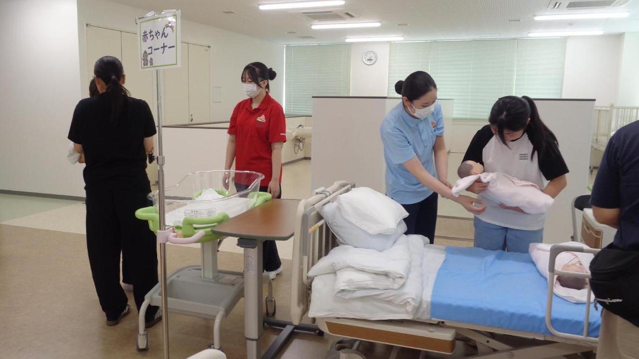 実習室で赤ちゃん人形を抱っこしている参加者たちの写真