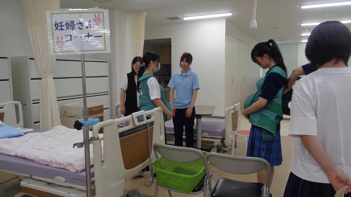 実習室で妊婦体験スーツを着た参加者たちの写真