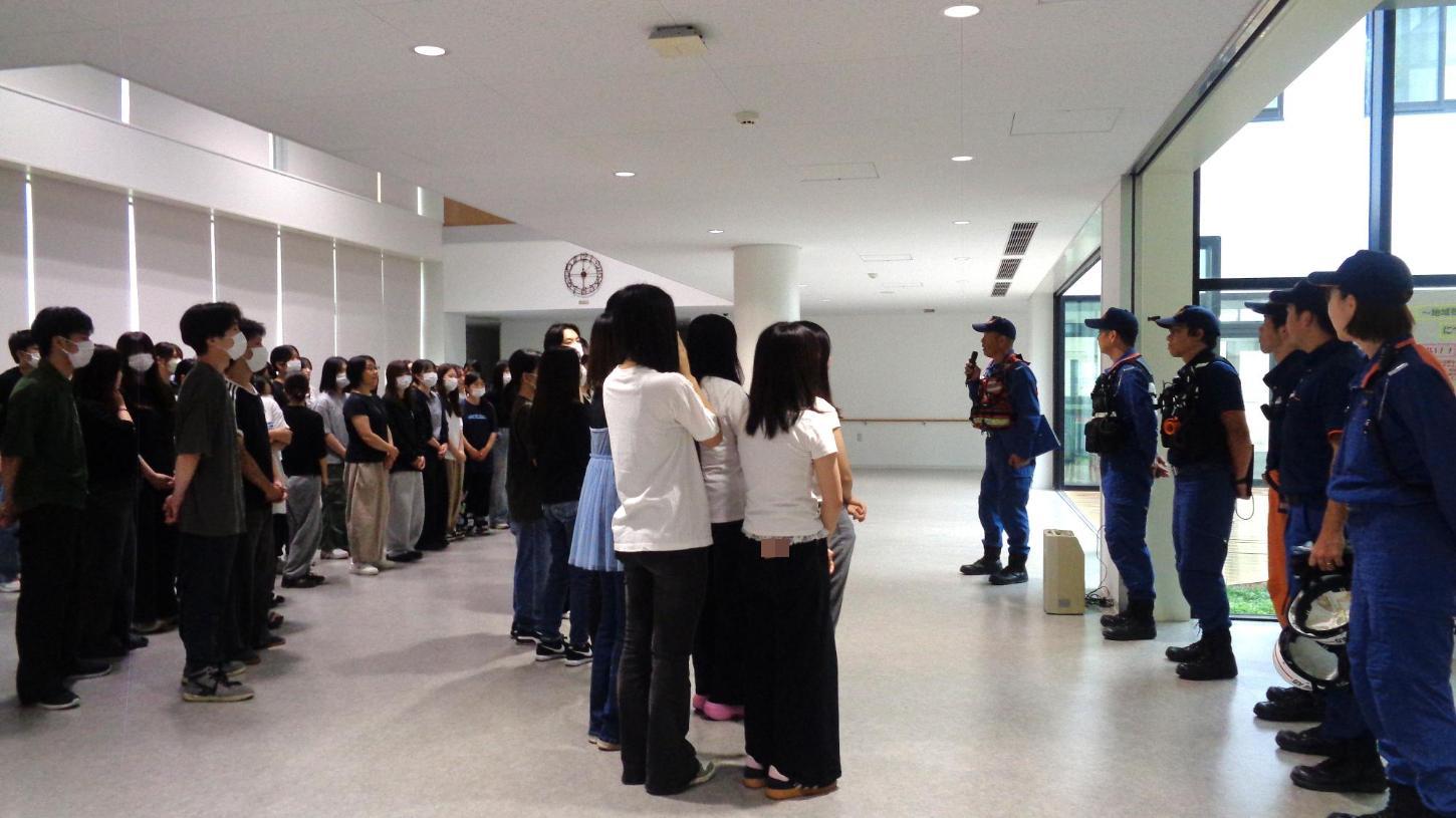 消防署員から講評を聞いている学生たちの写真