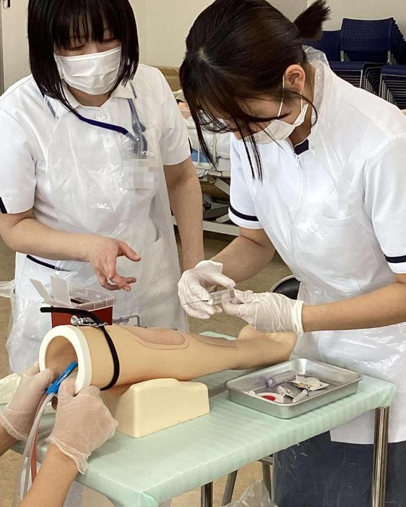 教員の話を聞きながら注射器を刺す準備をしている学生の写真