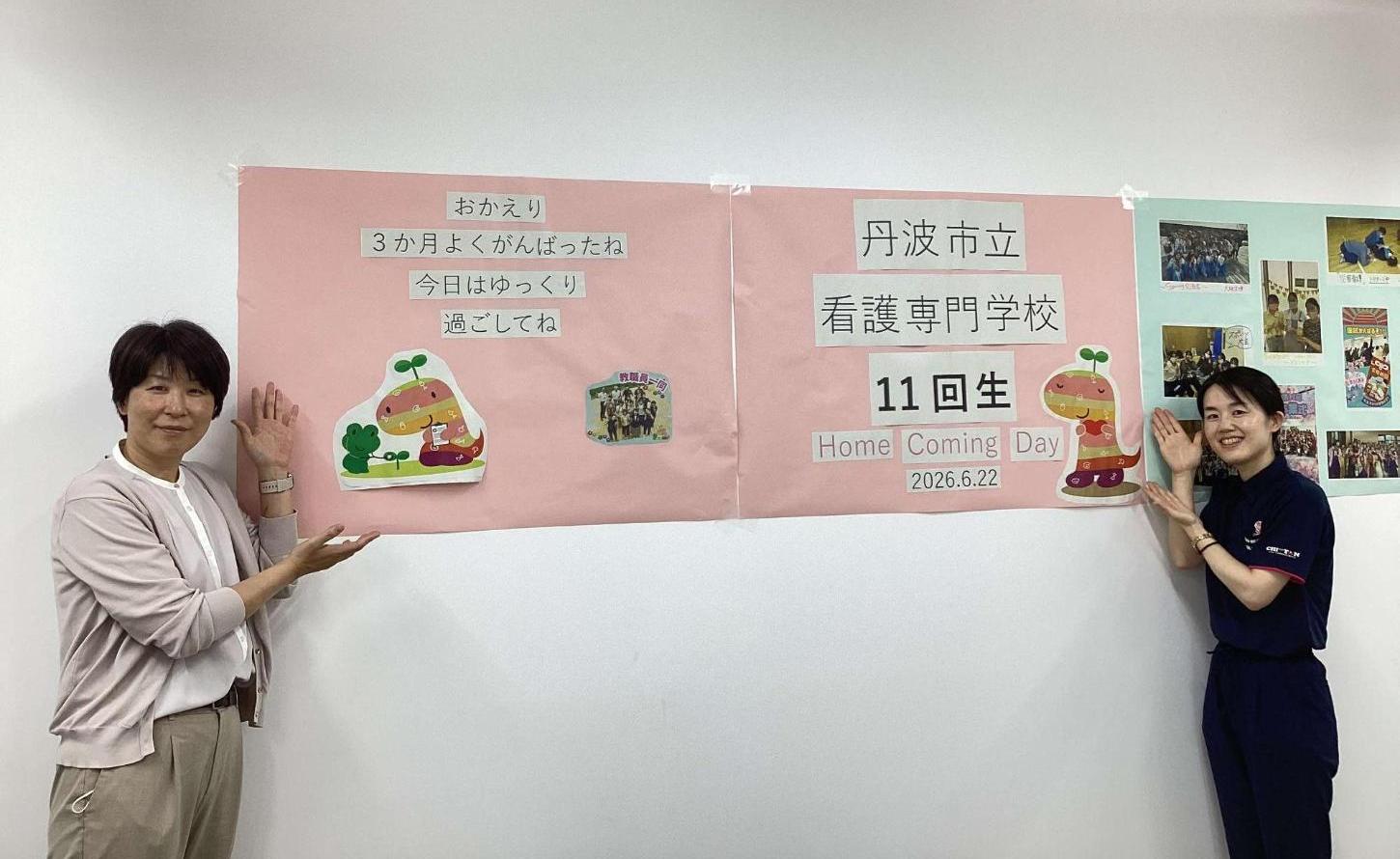 おかえり3か月よくがんばったね。今日はゆっくり過ごしてね。の文字と思い出の写真の掲示の前に立っている教員2人の写真