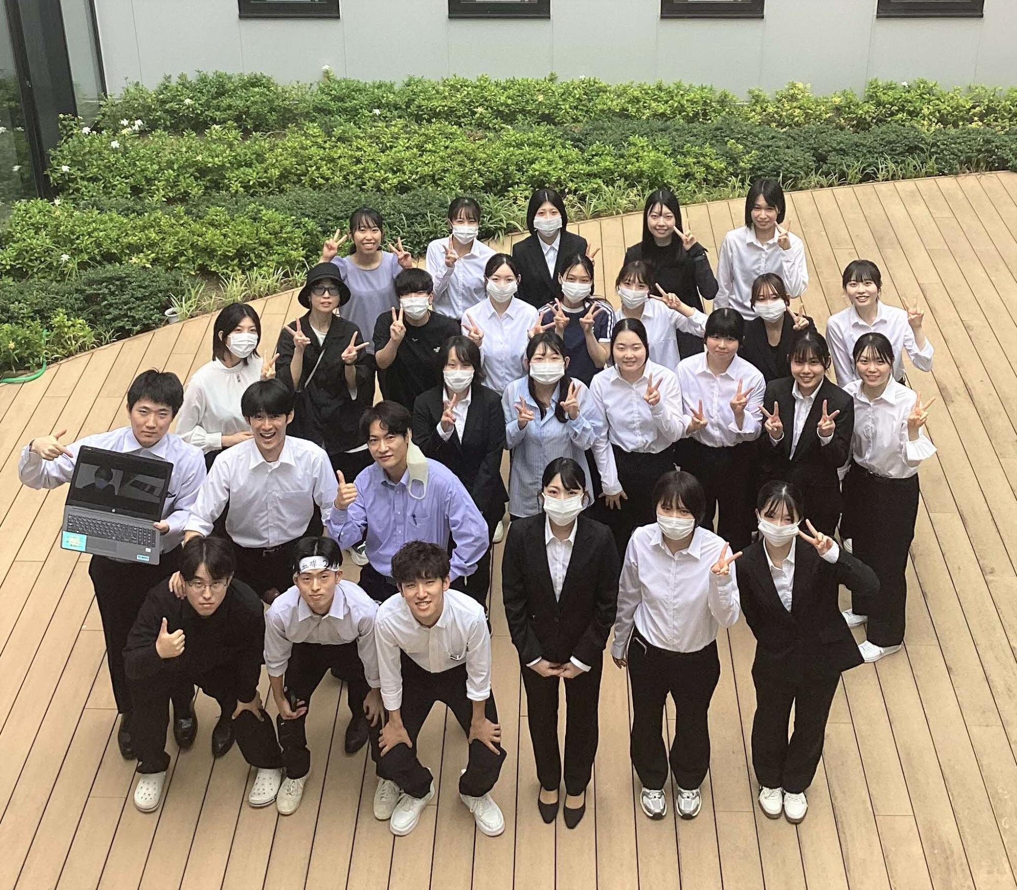 社会人1年目の卒業生28人が後輩に会いに来てくれて、パソコンの画面にリモートの参加が1人と、光庭で集合写真