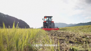 畑を耕す赤いトラクターの写真