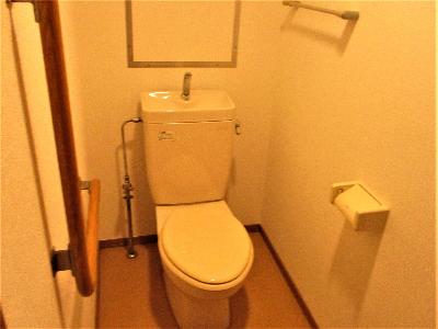 白を基調とした、木製の手すり付きのトイレ