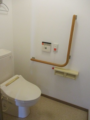 白を基調としたトイレで、床はベージュかかった色の写真