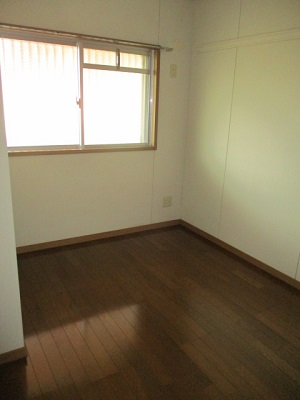白い壁に囲まれた部屋で、奥には窓があり、床は木目のフローリングの部屋