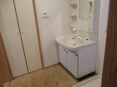 白を基調とした洗面台で、床がフローリングの洗面室の写真
