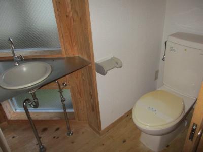 白を基調としたトイレで、床はフローリングの写真