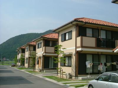 屋根が赤瓦で覆われている、外壁がベージュ色の戸建てが並んだ写真