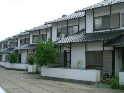 外壁が白色で瓦葺き屋根の2階建て建物が斜めに並んでいる写真