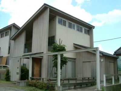 外壁が木張りになっている片流れ屋根の建物を斜めから撮影した写真