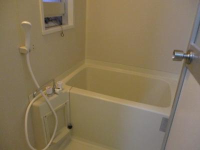 押戸を開けて撮影した白を基調とした浴室の写真