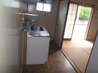 流し台以外の家具が何も置かれていない部屋の写真