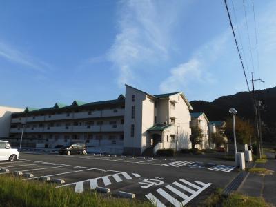 駐車場が併設されている3階建て団地の写真