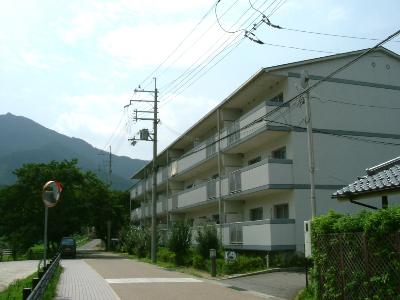 3階建ての集合住宅団地の外観を斜めから撮影した写真
