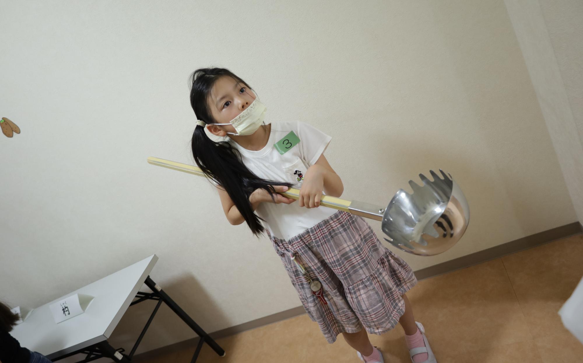 歯付きお玉を持つ様子