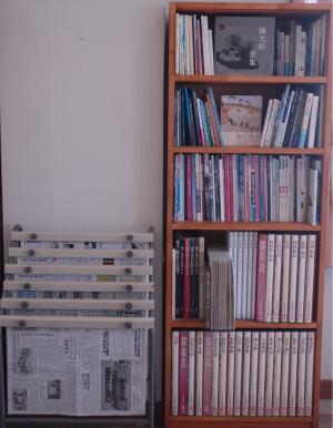 本棚と新聞のラックが並んで置かれている写真
