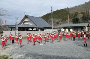 赤と白の同一ユニフォームを着た子供たちが屋外で演奏している写真